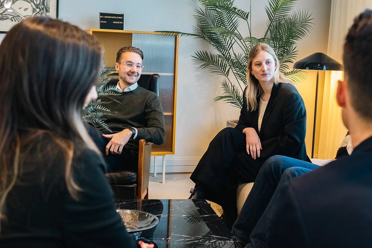 Jobba hos Vimab BESS Fyra personer sitter i en modern kontorslounge och samtalar. Två kvinnor och två män möter varandra, med växter och modern inredning i bakgrunden. Den avslappnade, professionella atmosfären återspeglar hur det är att jobba hos oss.