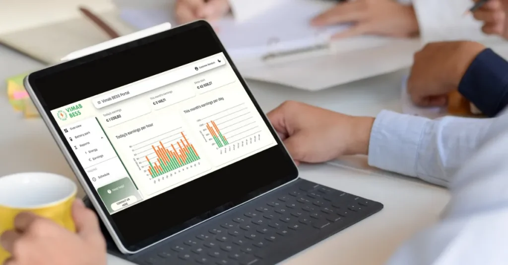 En person använder en surfplatta med tangentbord och får åtkomst till dataanalysdiagram och grafer via en portal, medan andra arbetar i bakgrunden vid ett skrivbord.